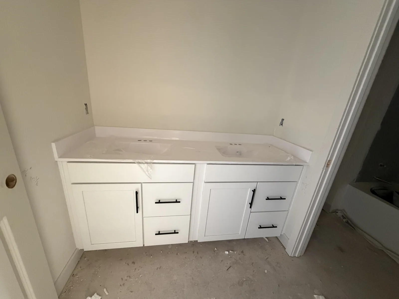 Double bathroom vanity with white cabinet doors and dark hardware
